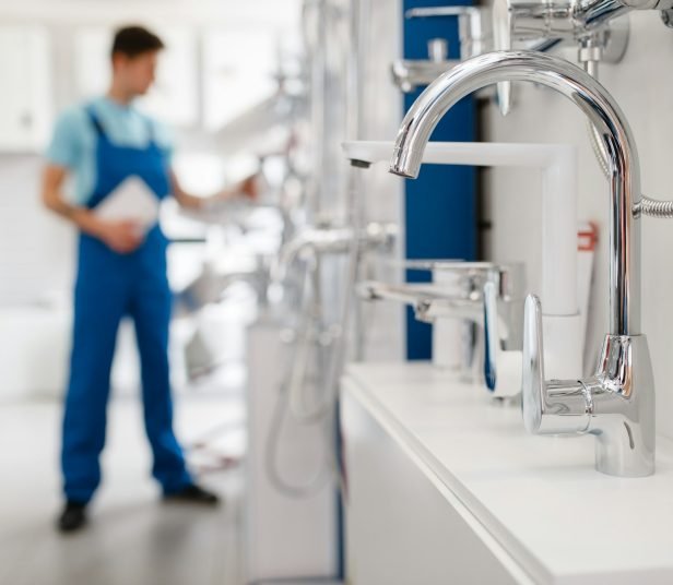 Plumber choosing faucet in plumbering store