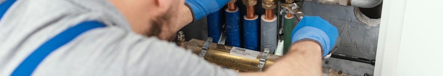 Professional plumber installing plumbing manifolds